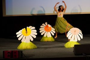 dzieci i nauczycielka przebrane za kwiaty na scenie