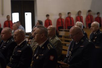 Delegacje służb mundurowych siedzące podczas nabożeństwa