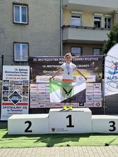 Aneta Suwaj z TL Athletics na podium z flagą Jastrzębia-Zdroju