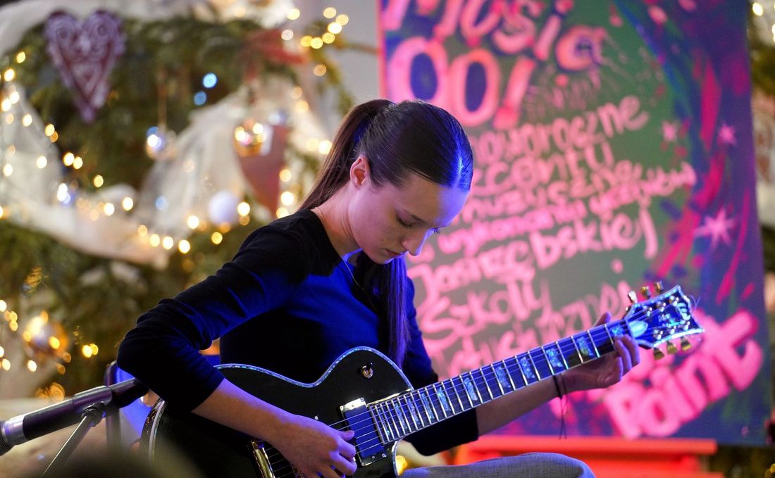 Uczestniczka koncertu grająca na gitarze