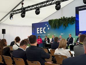 Publiczność ujęcie z tyłu, na scenie paneliści siedzą na fotelach