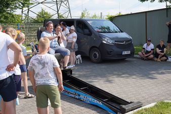 Mężczyzna testuje symulator zderzeń WORD Katowice na specjalnej rampie, otoczony przez instruktorów i przyglądających się przechodniów