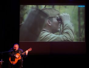 Artysta i wizerunek na ekranie źołnierza patrzącego w lornetki
