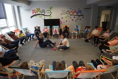 DZieci w kółku, siedzące na leżakach