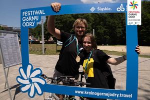 Uczestnicy rajdu rowerowego na OWN odbierają medale i robią pamiątkowe zdjęcia.