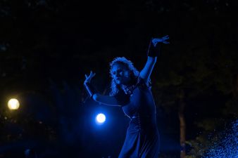 Kobieta tańcząca na tle ciemnych świateł
