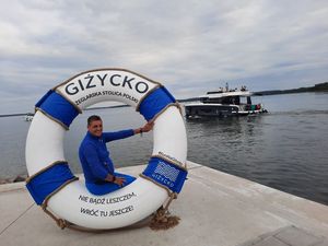 Zdjęcie pamiątkowe w kole ratunkowym z napisem "Giżycko".