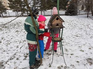 dzieci dokarmiają ptaki