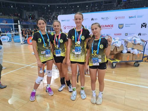 Trenerka i cztery zawodniczki z dyplomami i medalami w strefie foto