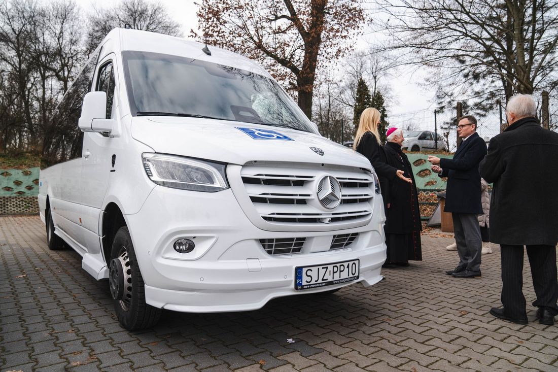 nowy biały autobus obok osoby odbierające pojazd