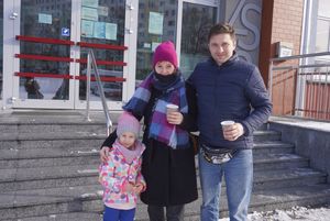 Trzyosobowa rodzina pozuje do zdjęcia przed sztabem