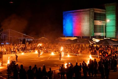 Zdjęcie przedstawia podświetlony budynek Łaźni Moszczenica, przed którym odbywa się pokaz Teatru Ognia Mandragora.