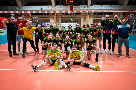 Ciesząca się i pozujaca do zdjęcia drużyna dziewczyn po wygraniu półfinału