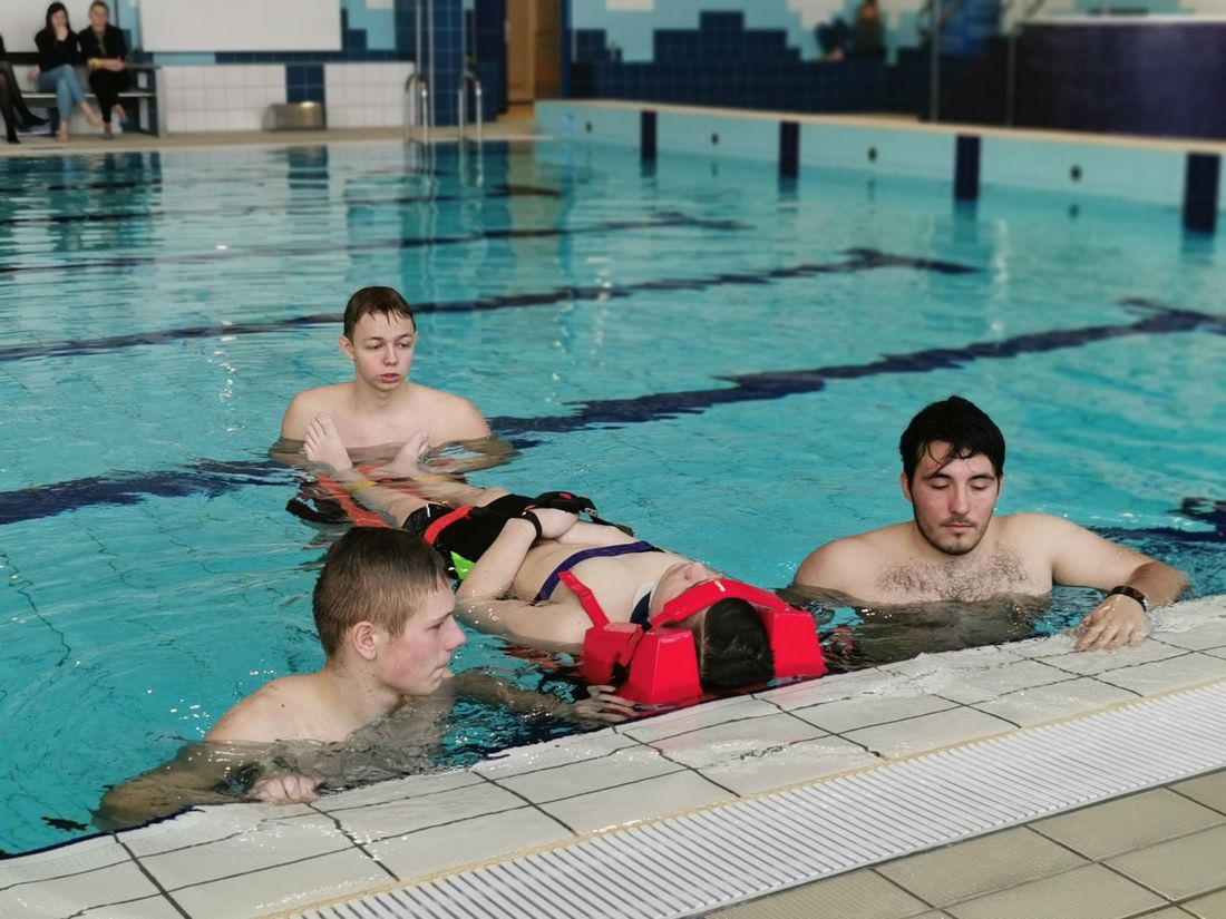 Zdjęcie uczniów w basenie, którzy ćwiącza ratownictwo wodne.