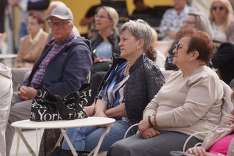 Seniorki siedzące wśród publiczności, w skupieniu przyglądające się występowi