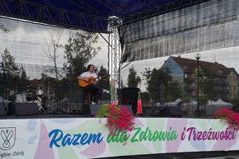 Gabriel Fleszar na scenie z napisem "Razem dla zdrowia i trzeźwości"