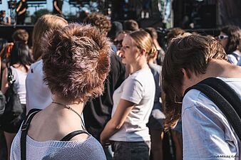 Dwie osoby odwrócone do sceny, nastolatki ze sobą rozmawiają