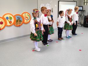 Grupa dzieci w strojach ludowych podczas uroczystości