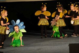 dzieci przebrane za kwiaty i pszczoły tańczą na scenie