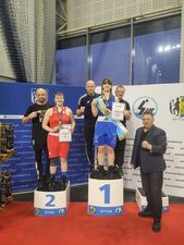 Zawodnczki stojące na stopniach podium, z nimi trenerzy i uczestnicy wydarzenia