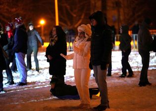 kobieta w białym ubraniu tancząca pod muzykę, obok stojący mężczyzna