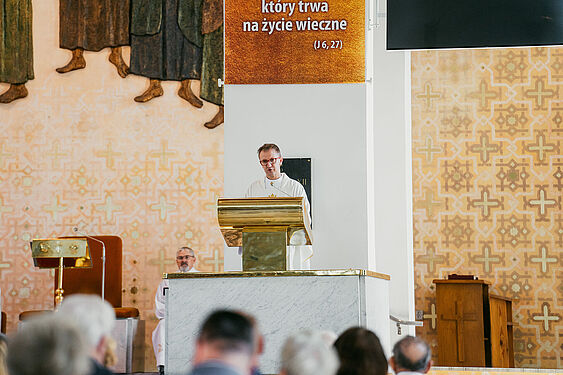 Ksiądz stoi przy mównicy na ołtarzu