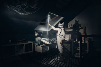 Ciemne zdjęcie, przedstawiające kosmonaute, uwięzionego w pokoju dziecięcym