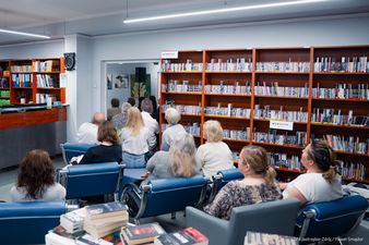 Uczestnicy siedzą w drugiej sali