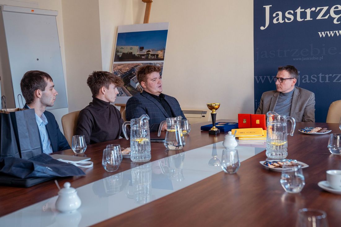 Uczniowie szkoły siedzą przy stol e z prezydentem