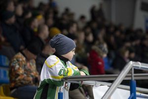 Młody kibic ogląda mecz z trybun.