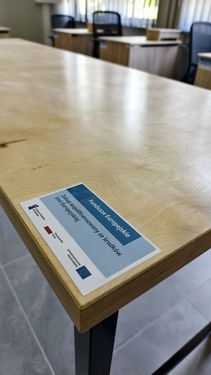 Widok na biurko, na którym jest naklejka z informacją, że dofinansowano ze środków europejskich
