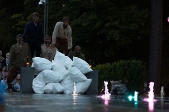 Grupa osób stojących za workami