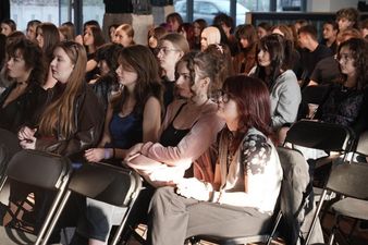 młodzi ludzie siedza na krzesłach 