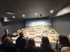 Uczestnicy spotkania oglądają makietę miasta, po lewej stronie stoi mężczyzna, który o niej opowiada