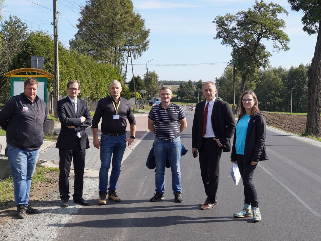 Zdjęcie przedstawia ludzi na drodze