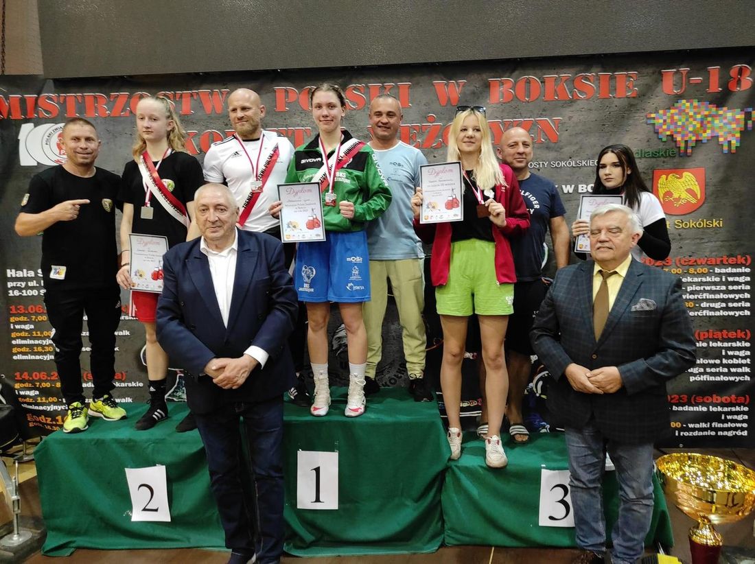 Zdjęcie przedstawia zawodniki na podium. 
