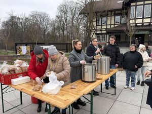 Trzy kobiety i prezydent Michał Urgoł przy stoliku podczas śniadania wielkanocnego na placu reprezentacyjnym w parku zdrojowym