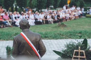 pomnik Henryka Sławika widziany od tyłu, przepasany wstęgą