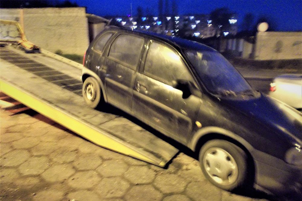 Na zdjęciu czarny pojazd wciągany na lawetę.