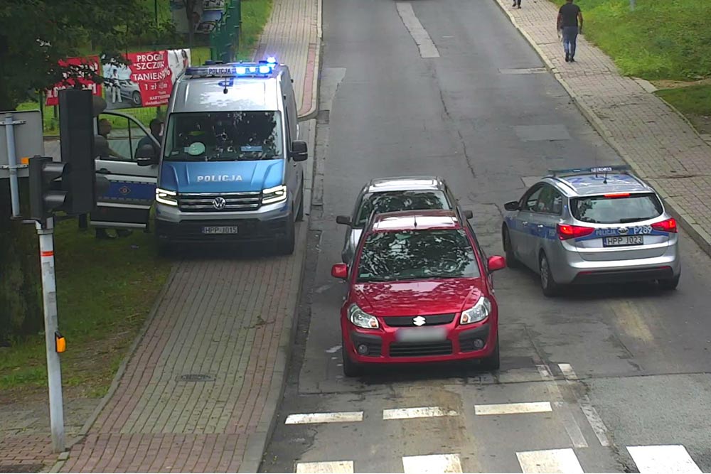 Kadr z monitoringu miejskiego - policja prowadzi czynności przy zatrzymanym pojeździe.