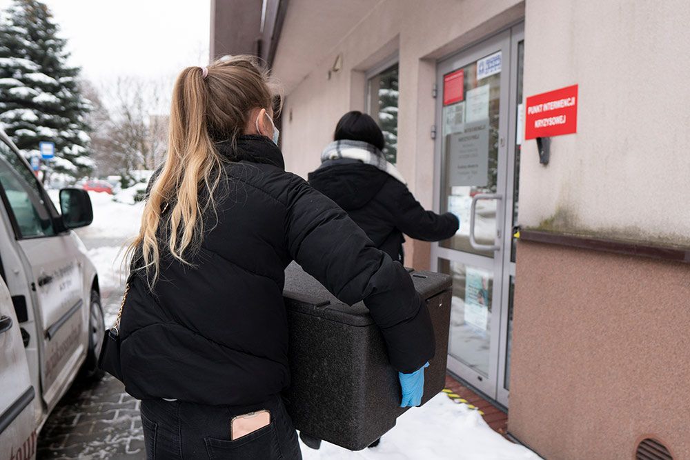 Zdjęcie przedstawia osoby dostarczające posiłki do Ośrodka Pomocy Społecznej.