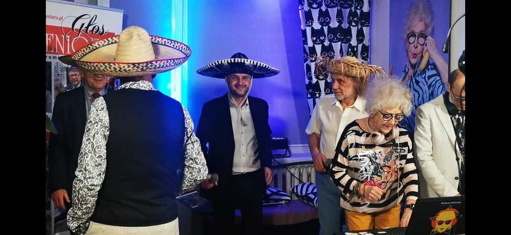 uczestnicy domówki dla seniorów w meksykańskich kapeluszach