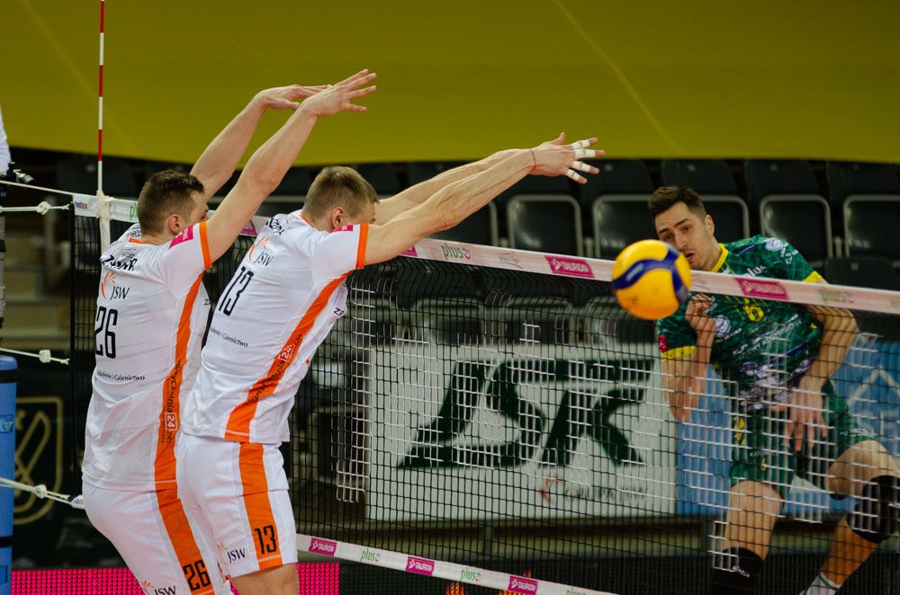 Przedstawia blok naszej drużyny - po drugiej stronie siatki atakuje zawodnik Zawiercia.