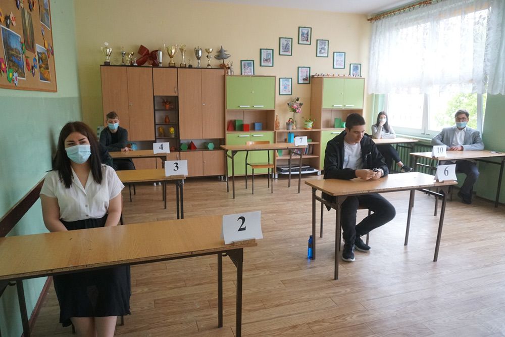 Zdjęcie przedstawia uczniów w ławkach oczekujących na egzamin.