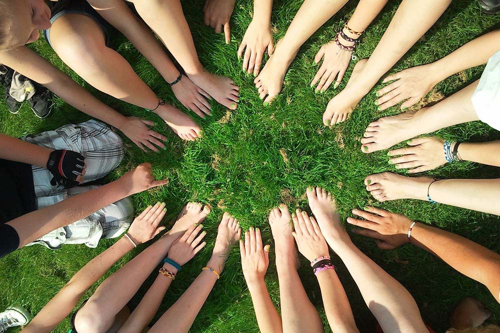 Zdjęcie przedstawia młodzież skupioną w kręgu.