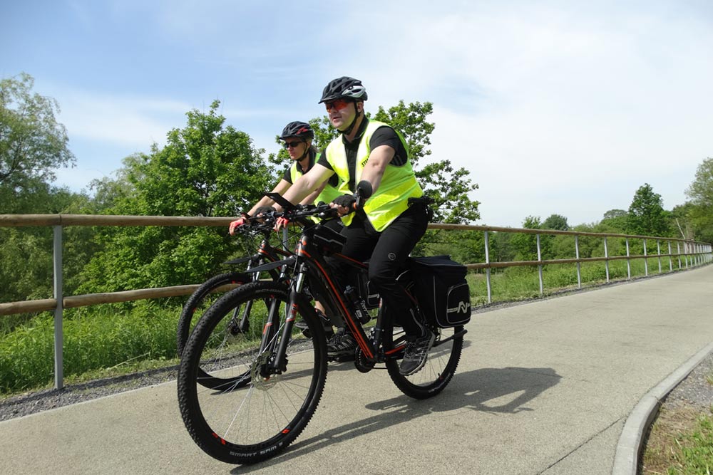 Zdjęcie przedstawia strażniczkę i strażnika na rowerach.