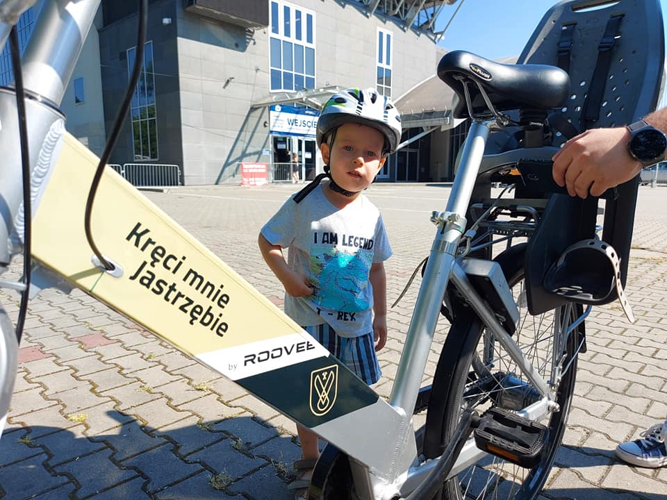 Małe dziecko, stojące koło roweru z napisem Kręci mnie Jastrzębie 