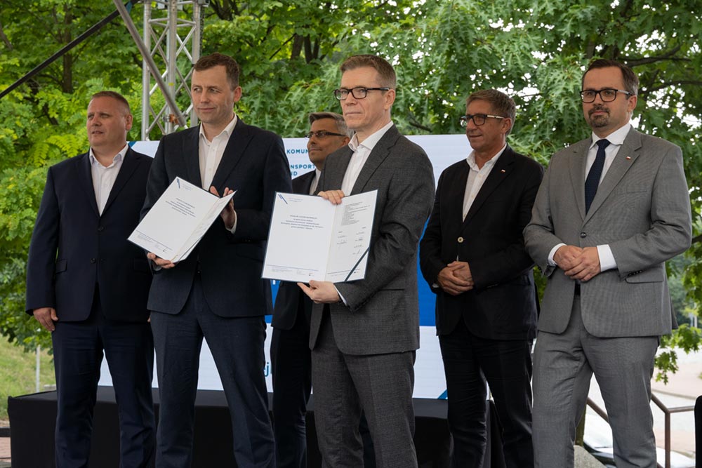 Uczestnicy konferencji prezentują podpisane dokumenty.