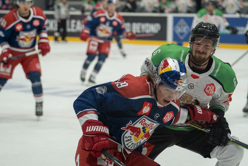 Walka przy bandzie hokeisty JKH i RB Salzburg.