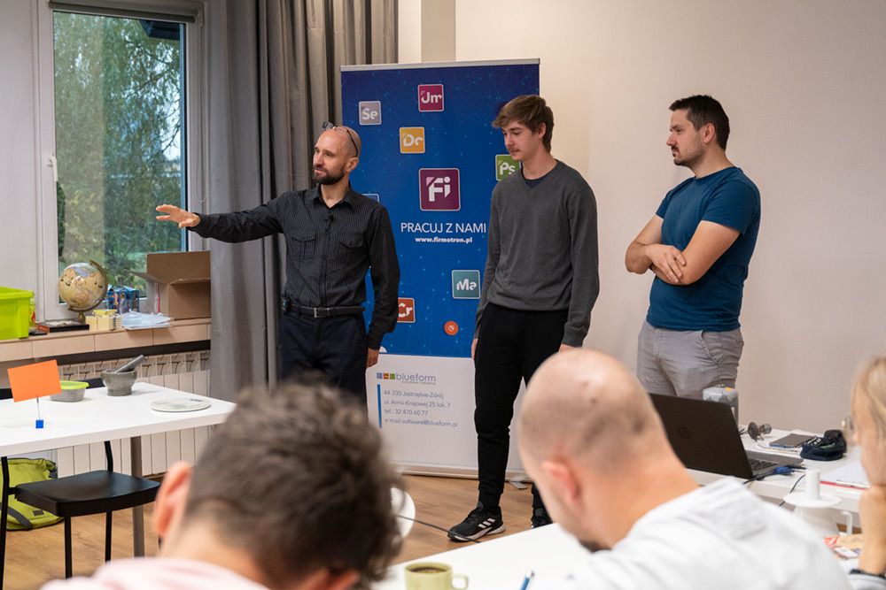 Wykładowca i dwaj uczestnicy warsztatów podczas zajęć praktycznych.